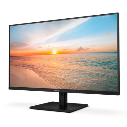 A Philips computer monitor with a black frame and stand, displaying a colorful sunset beach scene on a clean white background.