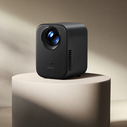 Black Xiaomi projector on a beige pedestal with a neutral background