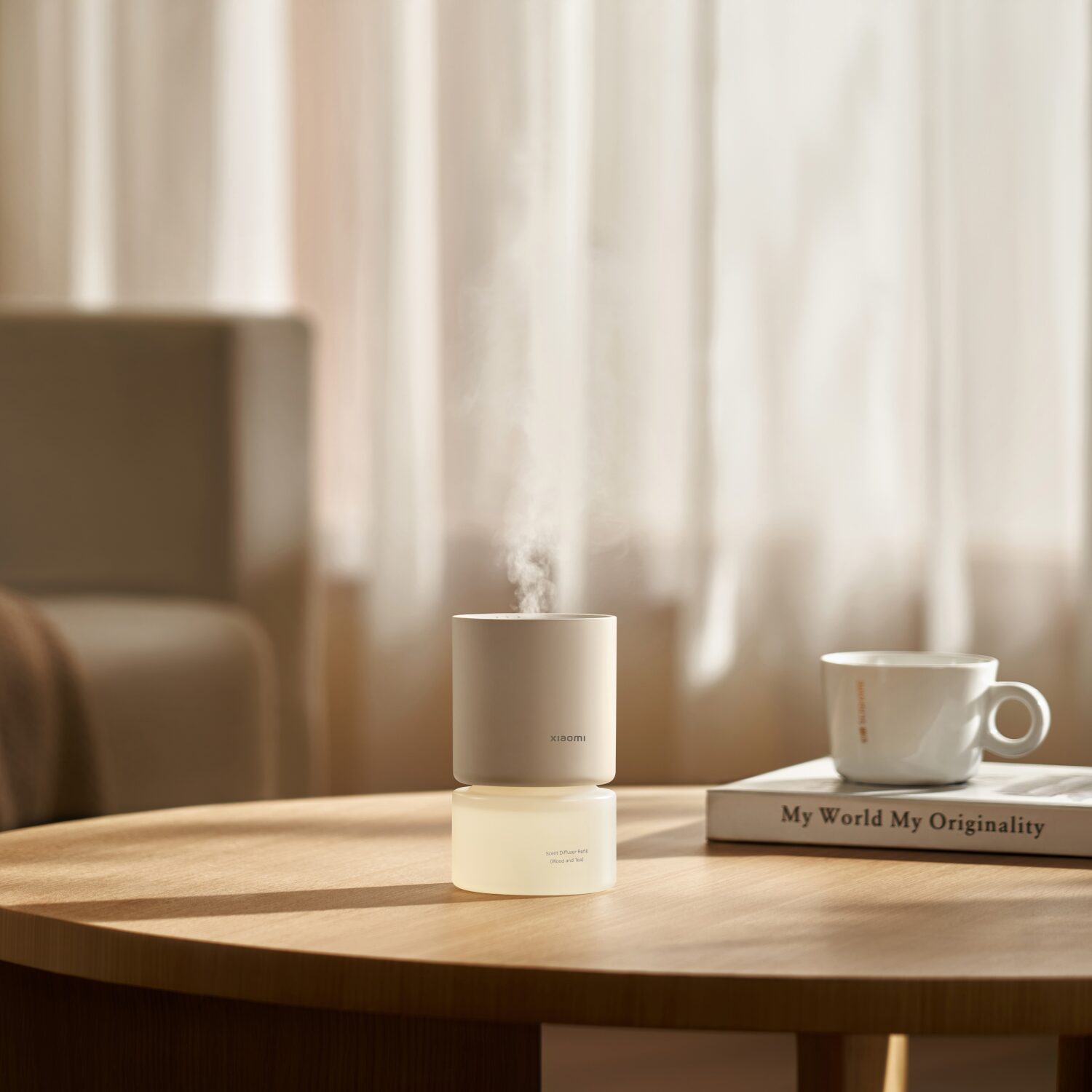 Xiaomi Smart Scent Diffuser and mug on a wooden table with a blurred background