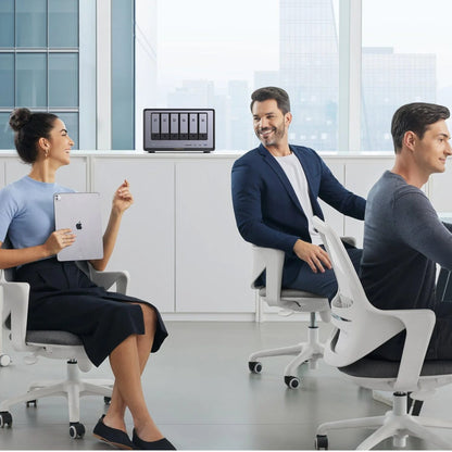 Three people sitting in office chairs in a modern office setting.