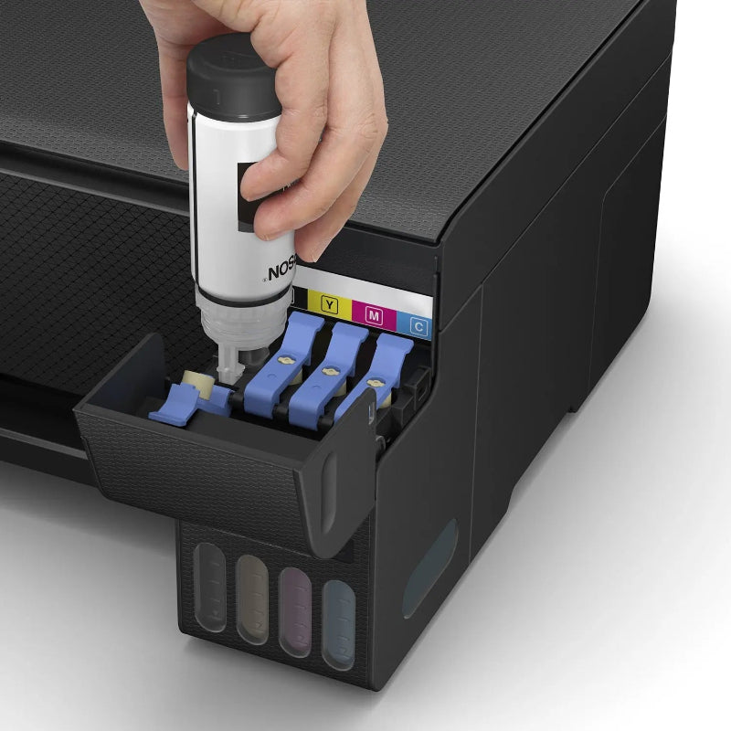 Hand inserting a ink cartridge into a printer with visible ink colors.