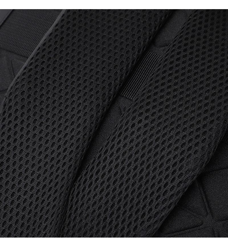 Close-up of black laptop backpack front pocket holding power bank, smartphone, and accessories, showing organized storage design.