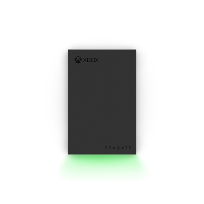Front view of the Seagate Xbox Game Drive 2TB (STKX2000400) — slim black external hard drive featuring Xbox and Seagate logos, illuminated by a vibrant green LED glow along the base, designed for Xbox Series X|S and Xbox One consoles.