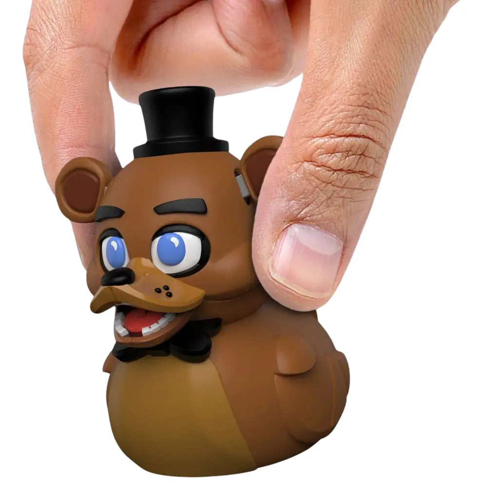 Tubbz Mini FNAF Freddy Vinyl Figurine with a person's hand holding it on a white background