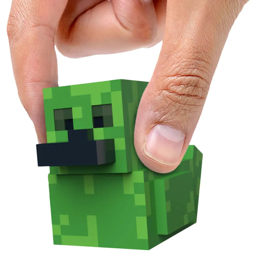 Tubbz Minecraft Mini Creeper in the shape of a duck held between fingers on a white background