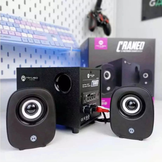 Pair of black Mikuso XS-38 speakers with visible branding on a white surface, with a blurred background.