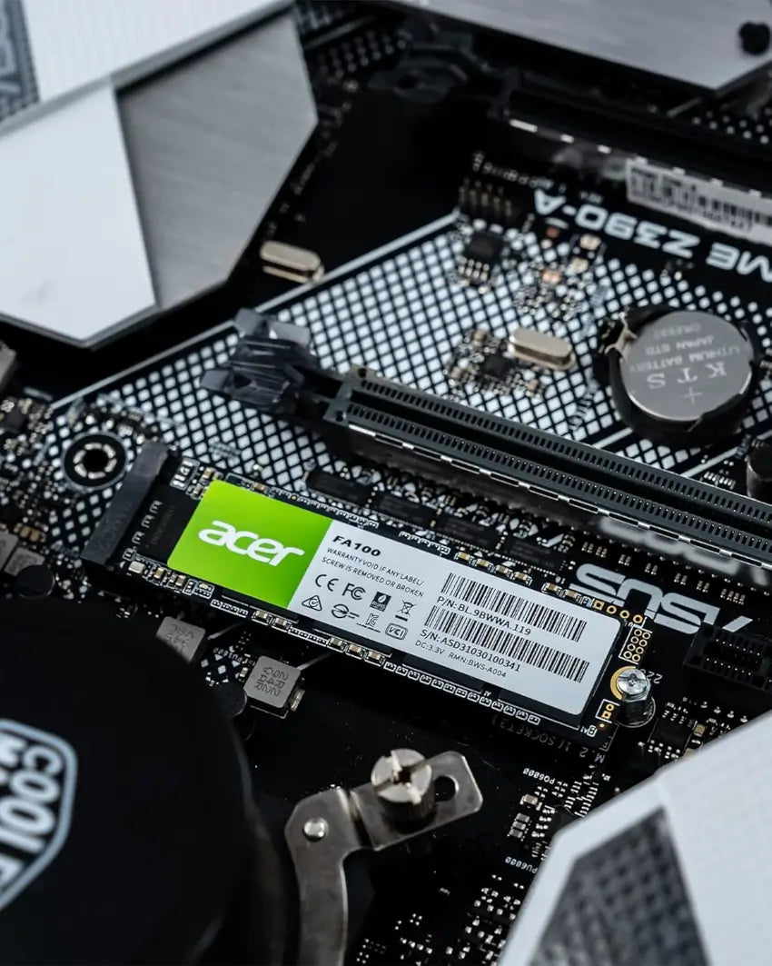 Close-up of a computer motherboard with an Acer solid-state drive installed.