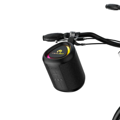 A black portable Bluetooth speaker with a textured fabric grille and a circular top panel featuring a yellow and pink logo, shown mounted on a bicycle handlebar against a white background.