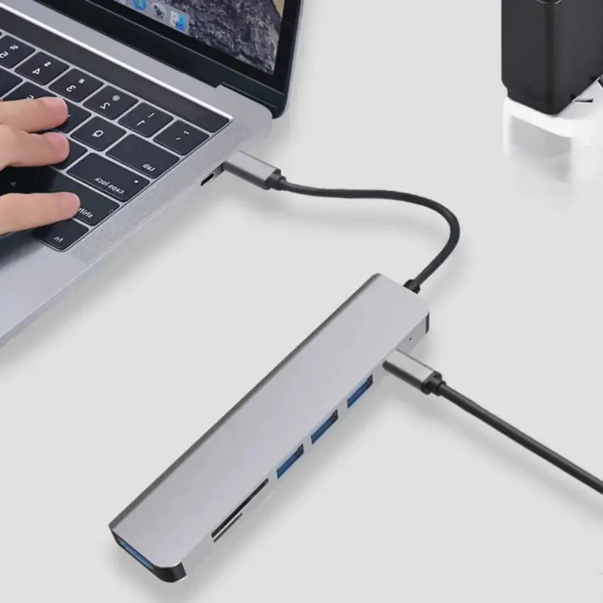 USB hub connected to a laptop on a white surface