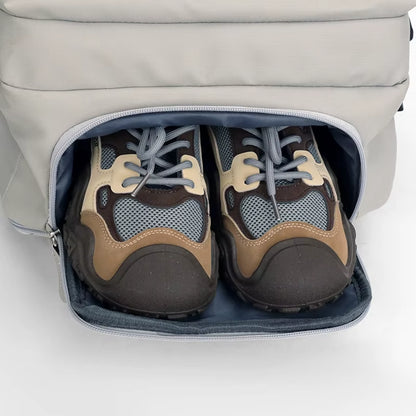 Pair of brown and black shoes inside the M-Link 15.6" Multi-compartment backpack with padded straps and handles in beige